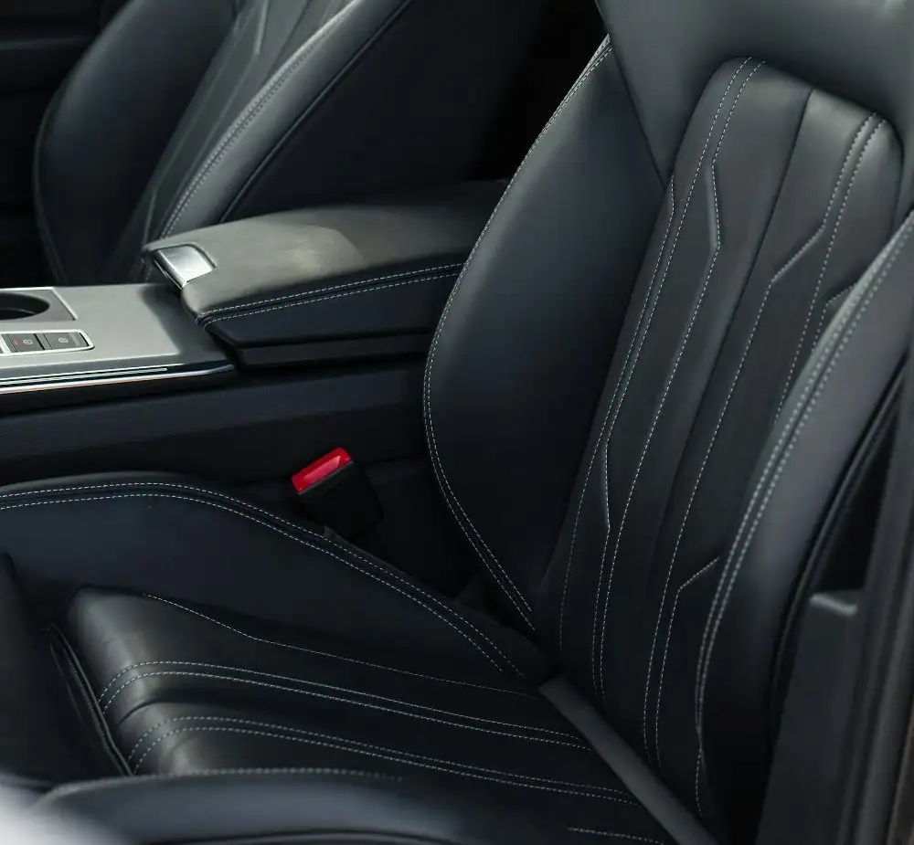 Black leather front seat with grey contrast stitching and the centre console, after cleaning and conditioning